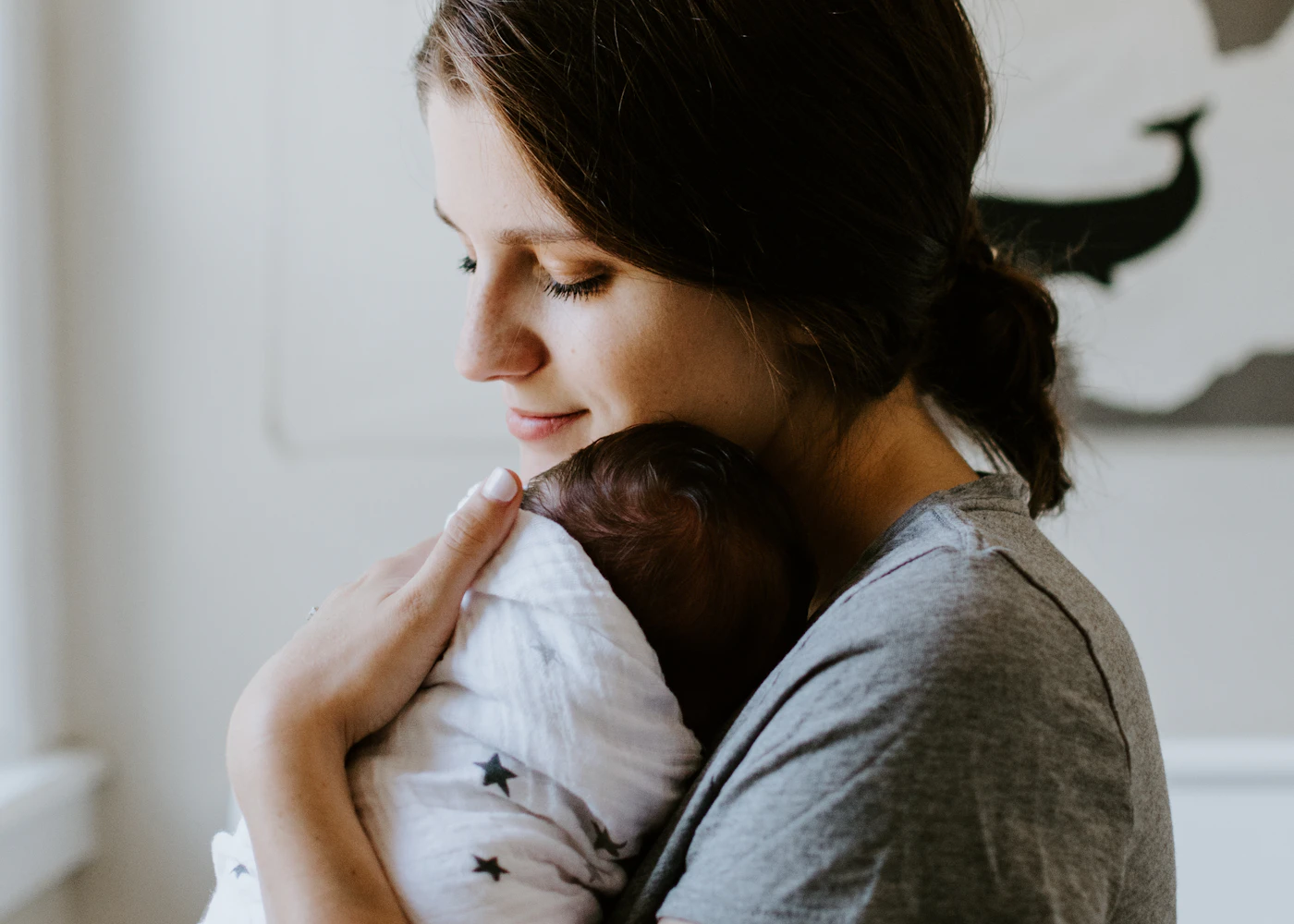 A mother holding her baby in warm natural light
